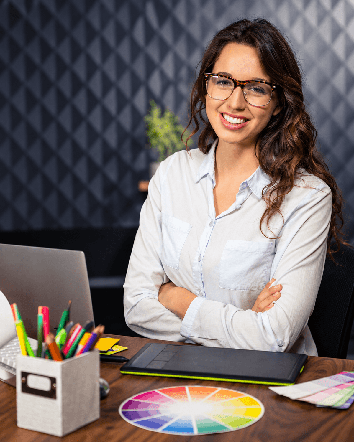 Creative professional at a design workspace, representing DIY+ website creation and management in Custominder.